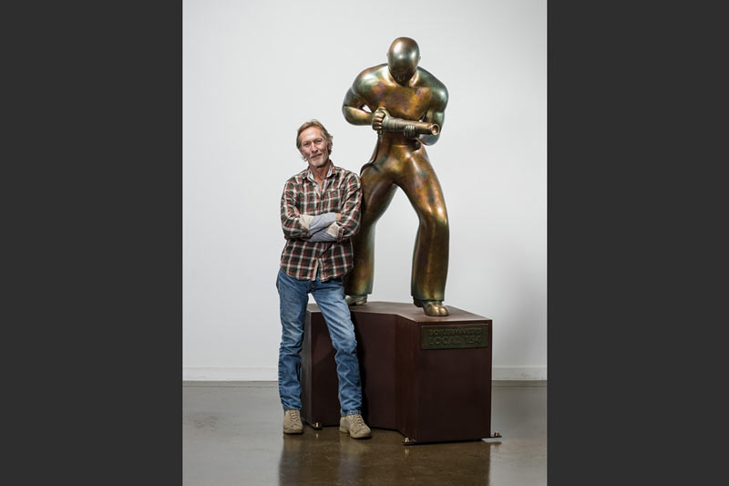 Charles Jones poses with a finished bronze Riveter.