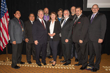 REP. ANN KIRKPATRICK (D-AZ 1st) with IP Newton Jones, third from left, and (l. to r.), Wesley Dale, L-627; Louis Dodson Jr., L-4; AIP/D-CRS Gary Evenson; AIP/IR-CSO James Cooksey; IST Bill Creeden; ED-CSO/AD-AAIP Kyle Evenson; IVP J. Tom Baca; and Jacob Evenson, L-627.