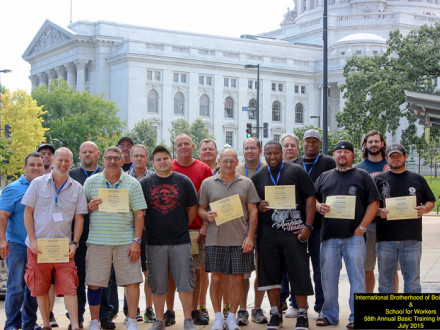 Los egresados del curso básico del 58o Instituto Anual de Verano en Madison, Wisconsin, de pie con sus certificados frente al Capitolio el 17 de julio.