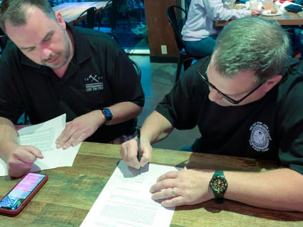 El director ejecutivo de las Operaciones del Sector Industrial, Tyler Brown, y Mike DeDomenic, presidente del nuevo sindicato de los Boilermakers en Honeywell, revisan los documentos de afiliación.