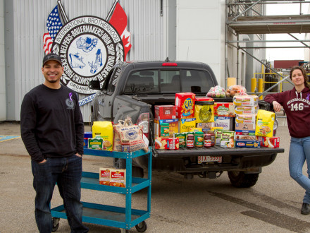 El representante de los Boilermakers de Calgary Steve Warren y la instructora de preaprendizaje Kayla Vander Molen recogen donaciones no perecederas en el salón del L-146 de Calgary para un banco de alimentos local de Calgary.
