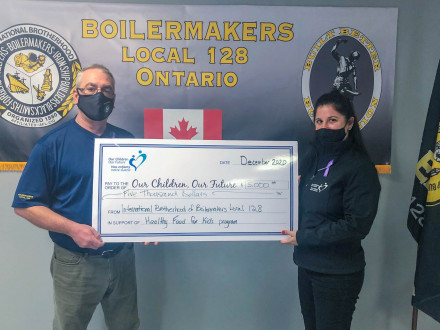 El agente de negocios del L-128 Joe Duprey entrega cinco mil dólares de parte del L-128 a Our Children Our Future en Sudbury.