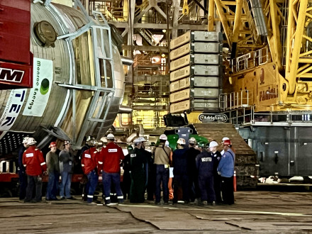 Los Boilermakers y otros trabajadores sindicalizados se reúnen antes del amanecer previamente de que comience la elevación del nuevo reactor. 