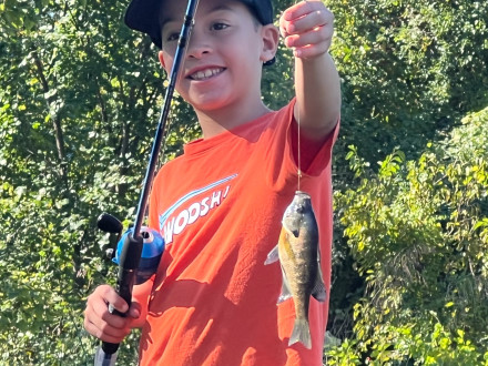 Un niño sonríe de orgullo con su primera captura del día