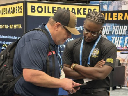 El organizador del área sudeste Carlos Brooks, a la derecha, habla con un invitado en el stand de los Boilermakers.