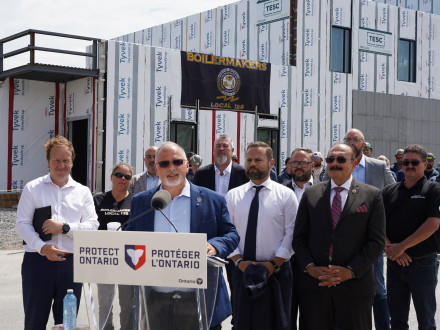 El gerente de negocios-secretario tesorero de la L-128, Stirling Munn, habla en una conferencia de prensa anunciando $5.7 millones en fondos del gobierno de Ontario para capacitación. El edificio al fondo representa las nuevas instalaciones en Sudbury, Ontario. 