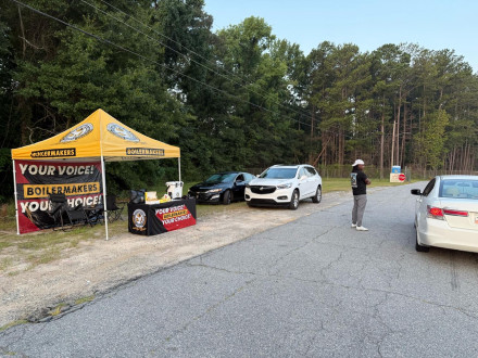 El organizador Carlos Brooks habla con un trabajador de Nichiha en la entrada de las instalaciones.