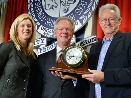 IP Newton B. Jones, center, presents a clock to commemorate IVP Jim Pressley’s 50 years of service during the LEAP conference last year. At left is Bridget Martin, Director of Political Affairs.