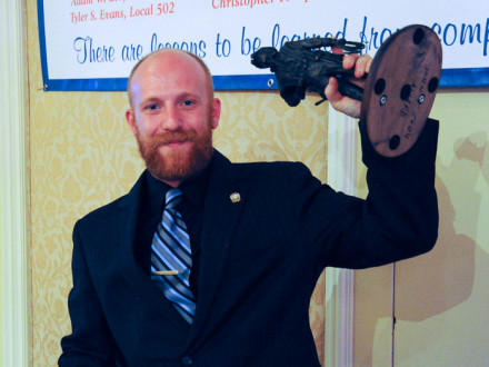 L-169’s Christopher Opalewski hoists the first place trophy after being named the top graduate apprentice for 2013.