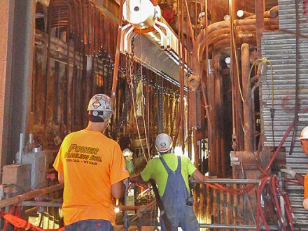 CAREFULLY – The new, five-story superheater header is hoisted by Boilermakers Local 27 members through an opening cut into the side of the building where the 17-story boiler is located.