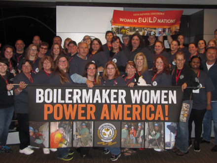 The Boilermakers’ contingent at the Women Build Nations conference holds up a banner to show their pride and solidarity.