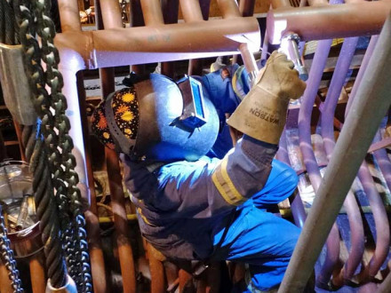 Hilary Peach travels out of Local 359 and often does confined space jobs in pulp mills. Here she welds tubes to a header. Photo courtesy of Gord Kappel.