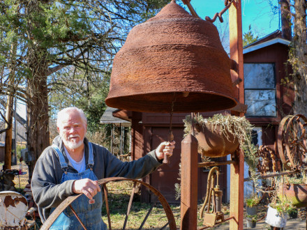 Retired L-592 Boilermaker Ed McCormack rings his latest piece of sculpture — an iron bell that weighs about 180 pounds. Photo credit: Patrick Ford, Okmulgee Times Editor