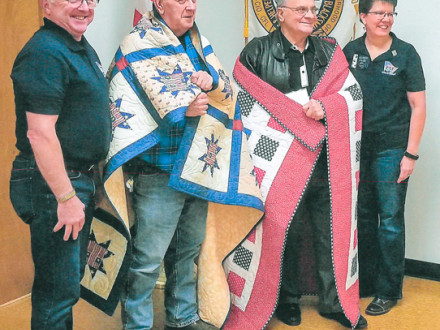 Two retired L-60 members receive a handmade quilt from the non-profit Quilts of Valor to thank them for their service during the Vietnam War. L. to r.: Rod Johnson, L-60’s John Williams and Jack Cooper, and Terry Johnson.  