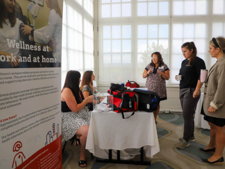 Conference participants chat at one of the booths set up at the health fair adjacent to the Canadian tripartite.