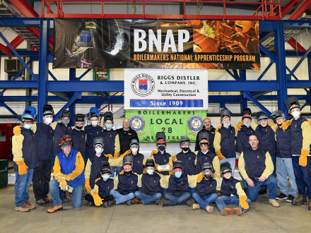Boy Scout Troop 230 members earn their welding merit badges at Local 28 with the help of L-28 assistant business manager and president Dave Addison, in back and at left of the sign, and L-28 BM-ST Jim Chew, to the right of the sign.