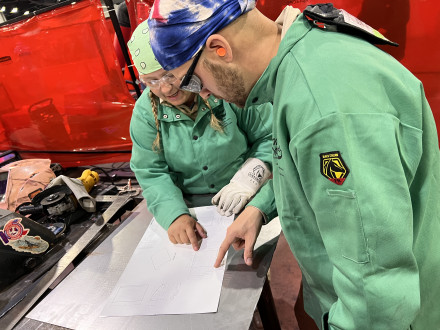 Nathan McCatty and Jill Osentoski study the blueprint during the welding fabrication competition at SkillsUSA.