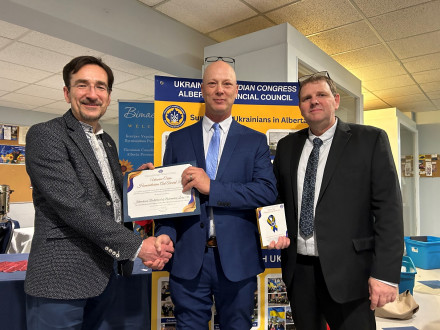 Business Manager Mack Walker accepts the Ukraine Crisis Humanitarian Aid Award from Danyleiko Oleksandr, Cousul General of Ukraine in Edmonton, with Assistant Business Manager Jason Speer.