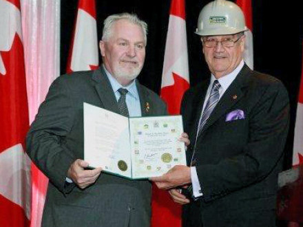 IVP Joseph Maloney, left, receives an award of excellence from Associate Minister of National Defence Julian Fantino.