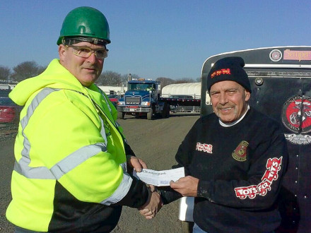 Don Hartney, L-29, left, gives Toys for Tots representative Tony Gatro a check for over $1,200.