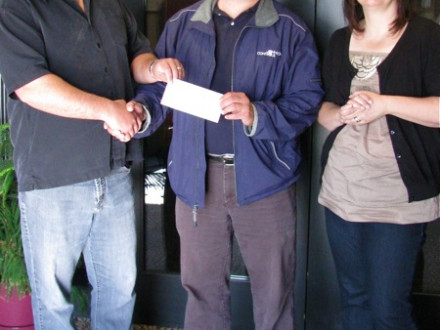 L-555 Business Rep Ted Stark, l., accepts a $5,000 check to fund a new award for