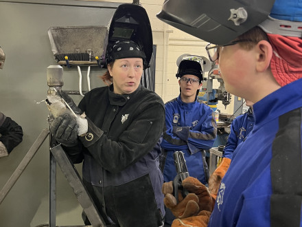 L-169 apprentice Amber Combs instructs two Fraser High School CTE students on buddy welding best practices.