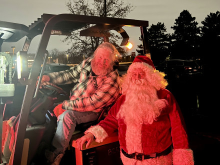 L-169 business agent Jamie Ratliff takes a break on the forklift for a photo opp with Santa.