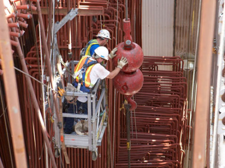 Two Boilermakers help direct a tube section lift. Photo courtesy of MOST/Martin Communications 