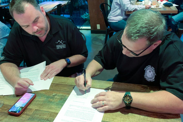 ISO Executive Director Tyler Brown and Mike DeDomenic, president of the new Boilermaker-affiliated union at Honeywell, review the affiliation paperwork.