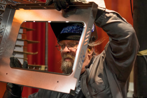 Mark Campbell, fabrication TIG welder, inspects his work after TIG welding a convection oven outer door skin that will hold window glass. 