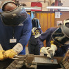Apprenticeship Coordinator Che Rocchild teaches eighth graders basic skills in the shop. 